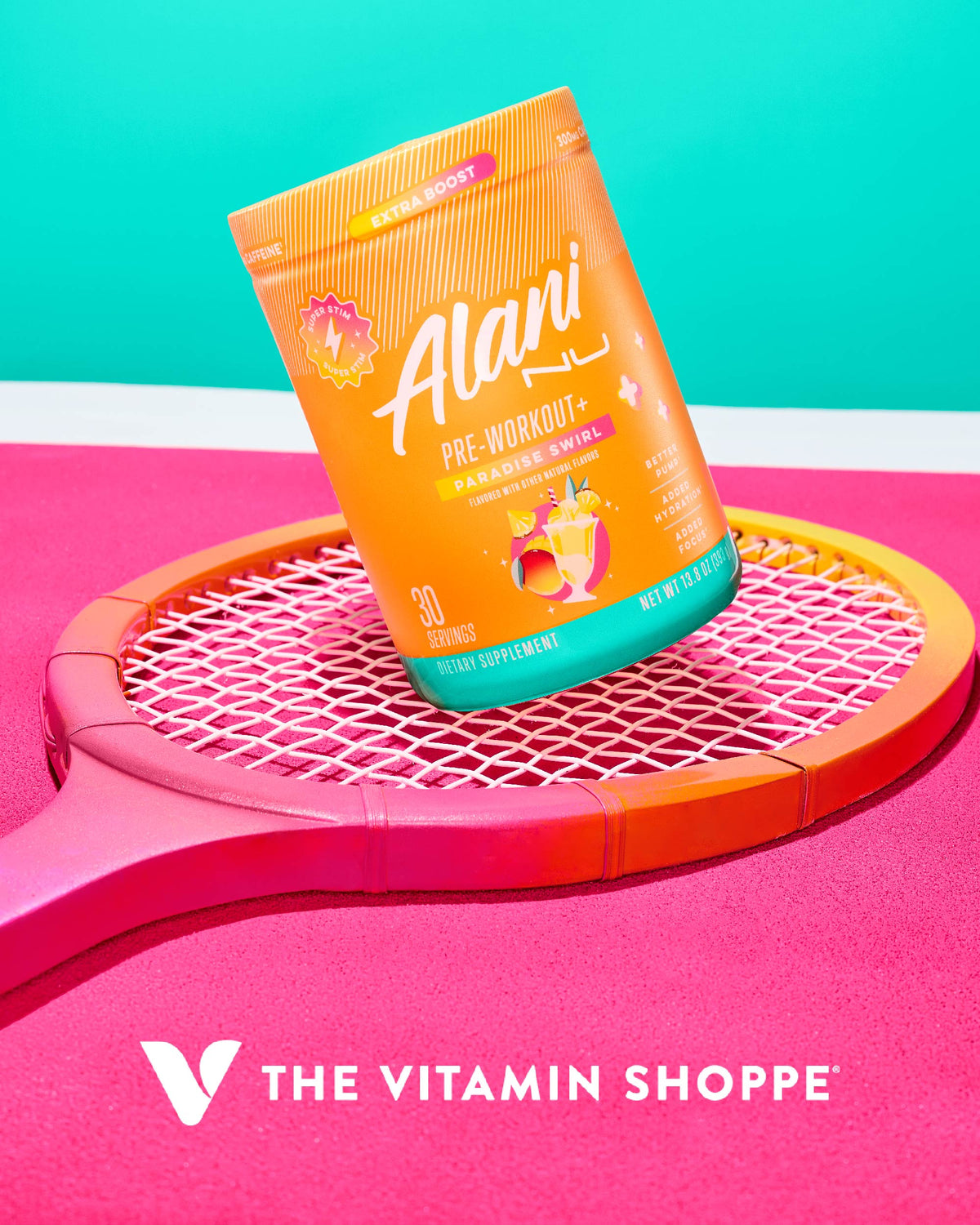 A container of Alani Nu's Pre-Workout + - Paradise Swirl supplement is placed on a pink and orange tennis racket with The Vitamin Shoppe logo below.