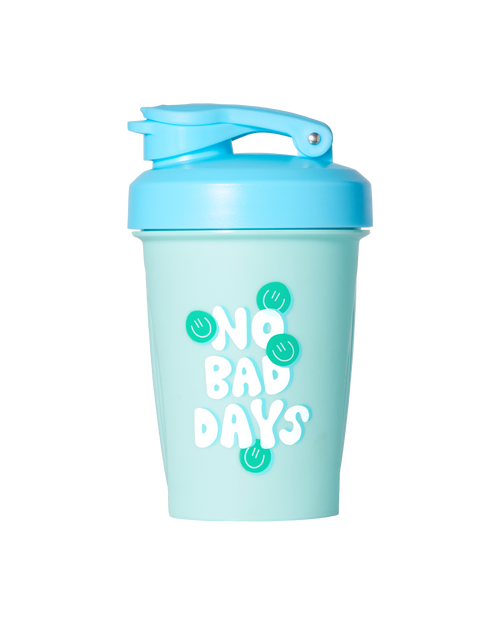 The Alani Nu 12oz Shaker - No Bad Days is a light blue shaker bottle featuring a blue lid and a flip-top cap. The front of the bottle displays the phrase "NO BAD DAYS" in white, along with green circular designs. It is BPA-free and dishwasher safe for effortless cleaning.