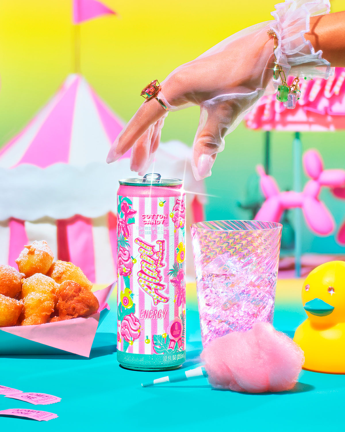 A woman&#39;s gloved hand reaching for a limited-edition Cotton Candy Alani Energy. Carnival treats, rides, and tents set the whimsical scene. 
