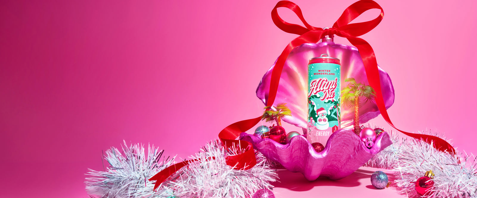 Alani Nu’s limited-edition, zero-sugar Winter Wonderland Energy Drink—now with a new-and-improved, cranberry sugar plum flavor—displayed in a festive pink clamshell, glowing with holiday sparkle.