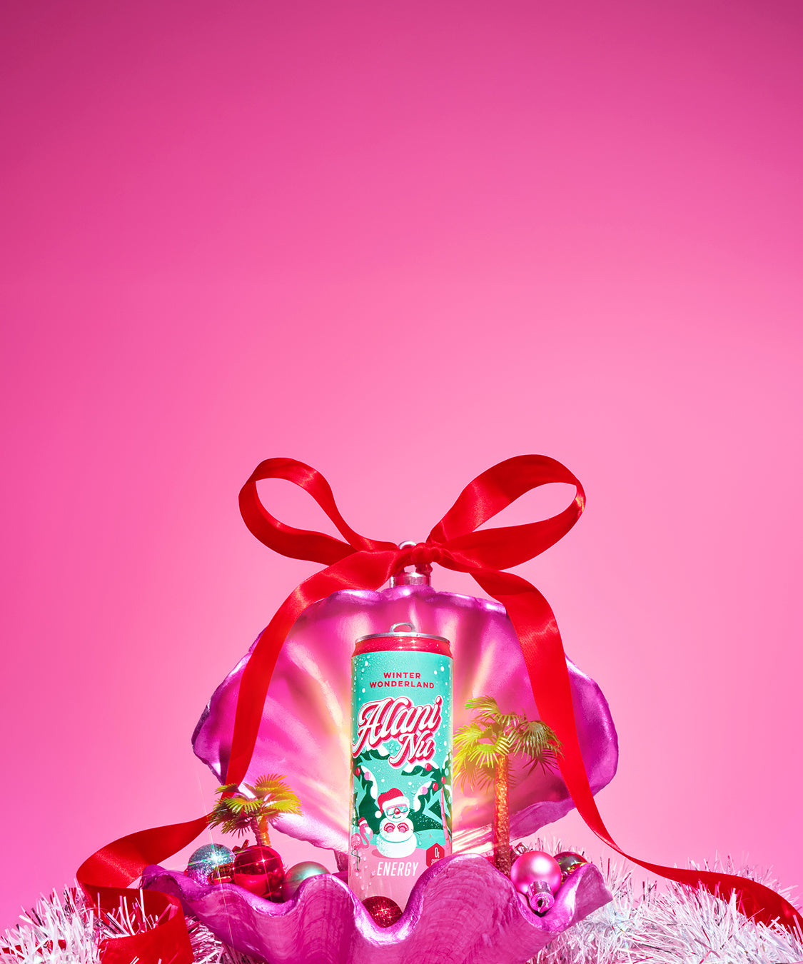 Alani Nu’s limited-edition, zero-sugar Winter Wonderland Energy Drink—now with a new-and-improved, cranberry sugar plum flavor—displayed in a festive pink clamshell, glowing with holiday sparkle.