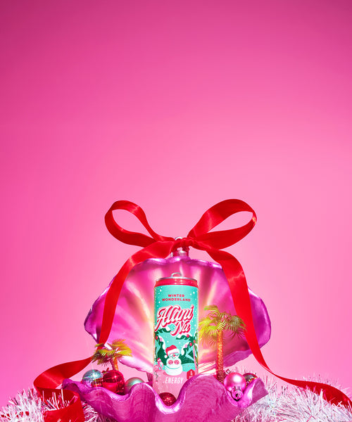 Alani Nu’s limited-edition, zero-sugar Winter Wonderland Energy Drink—now with a new-and-improved, cranberry sugar plum flavor—displayed in a festive pink clamshell, glowing with holiday sparkle.