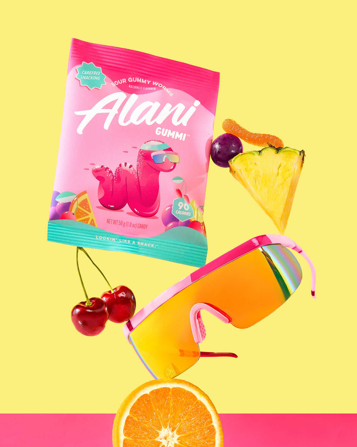 A variety of fruit, fashion glasses with Alani Gummi Sour Gummy Worms.