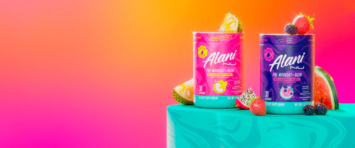 Alani Nu's thermogenic Pre-Workout+ Burn in Dragon Fruit Rush and Melonberry Blast shown on a pedestal with tropical fruits.
