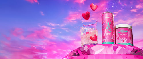 A Pink Slush Bundle atop a pink jewel. To the left, heart-shaped strawberry slices splash into a glass of Pink Slush Energy. 