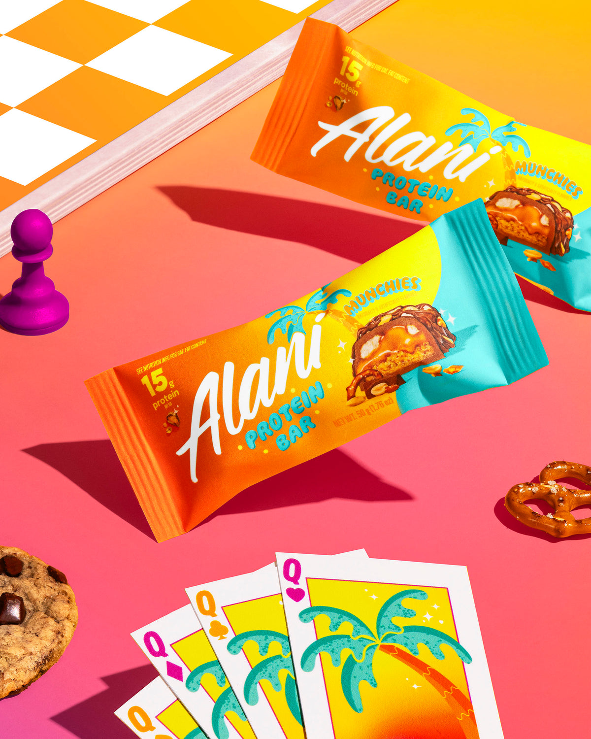 Two protein bars in flavor munchies are displayed next to a set of chess and cookies.