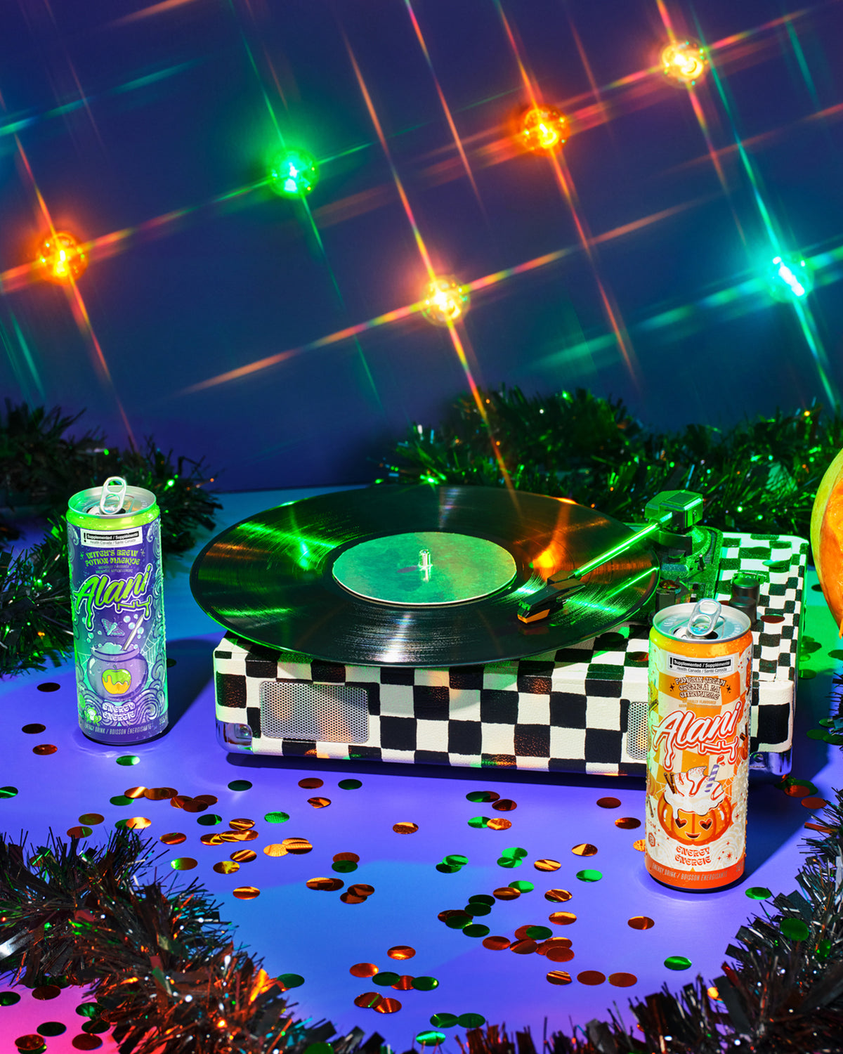 A caramel apple and Alani Nu&#39;s seasonal, zero-sugar Witch&#39;s Brew Energy Drinks, both 12oz and 8.4oz, on a silver platter. 
