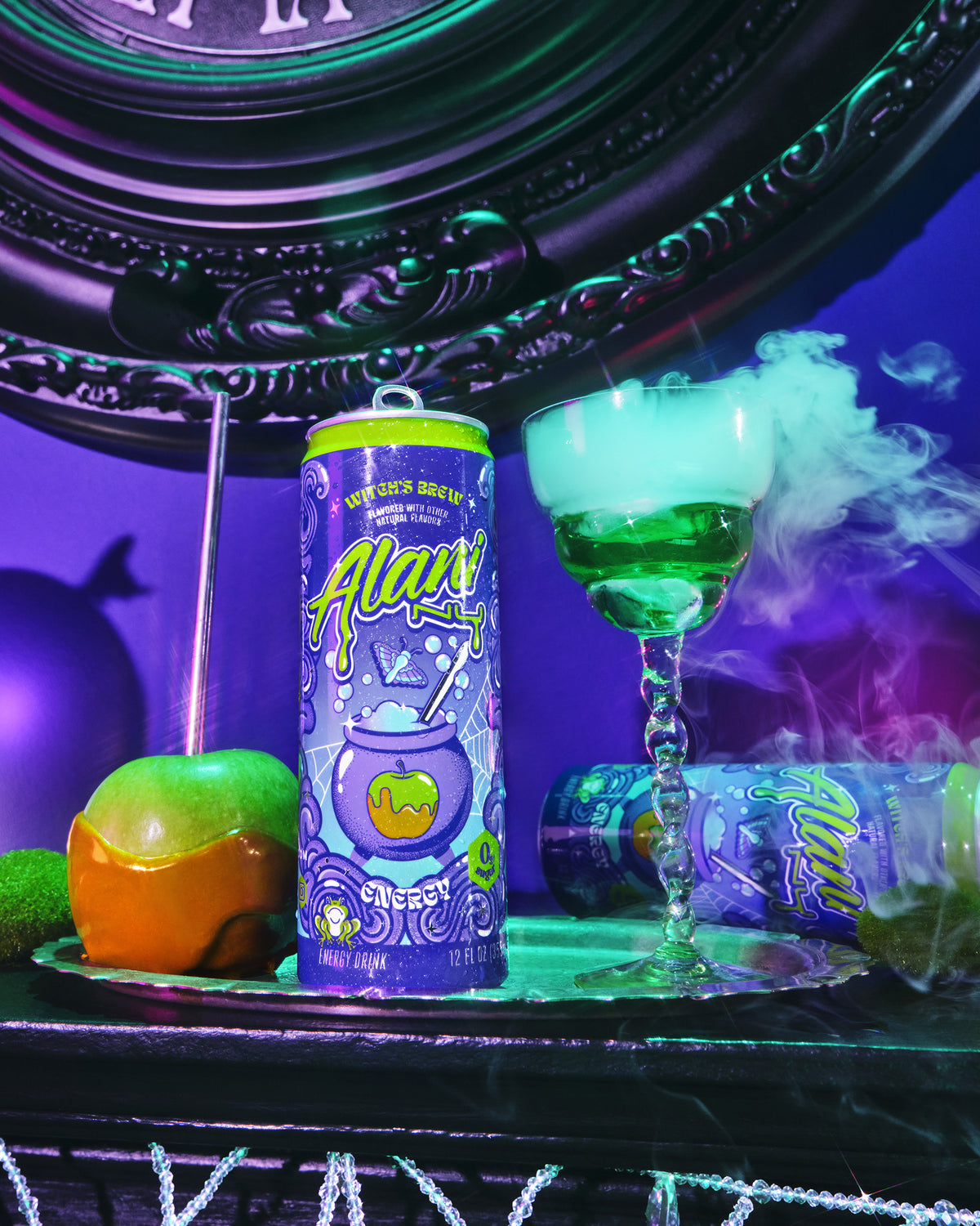 An Alani Nu Energy Drink - Witch&#39;s Brew can, a vibrant green cocktail in a glass, and fruit sit on a black table illuminated by dramatic purple and green lighting.