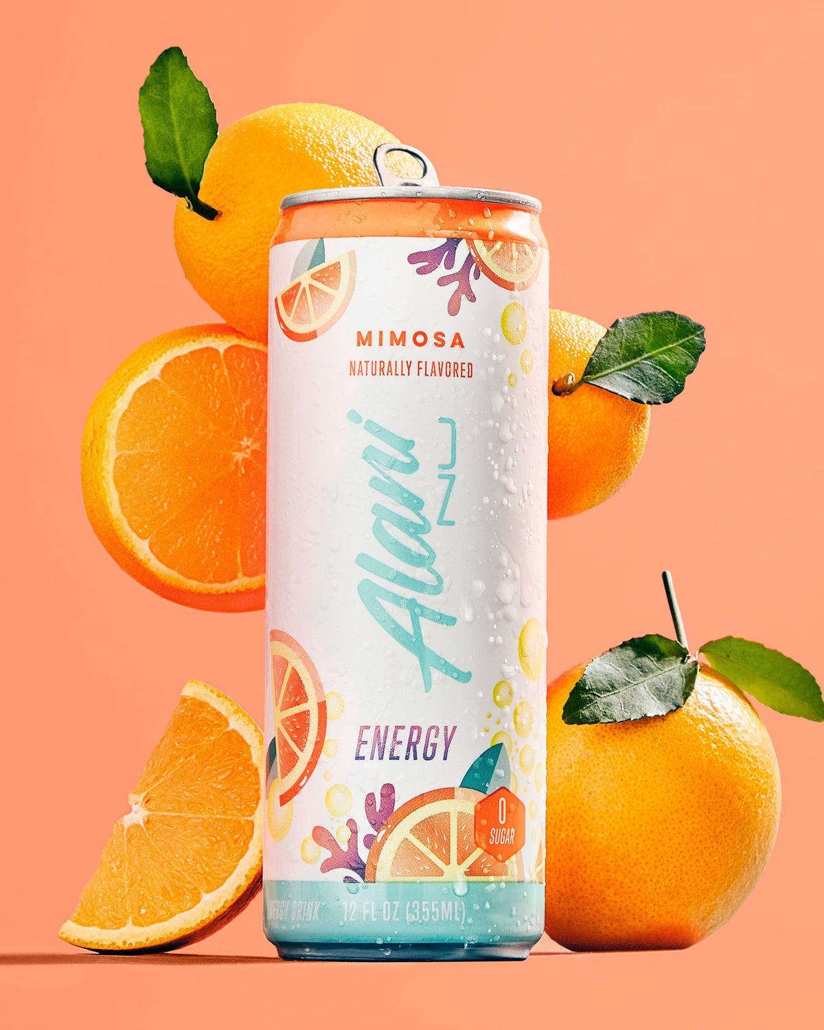 A 12 fl oz can of Alani Nu Mimosa energy drink surrounded by oranges.
