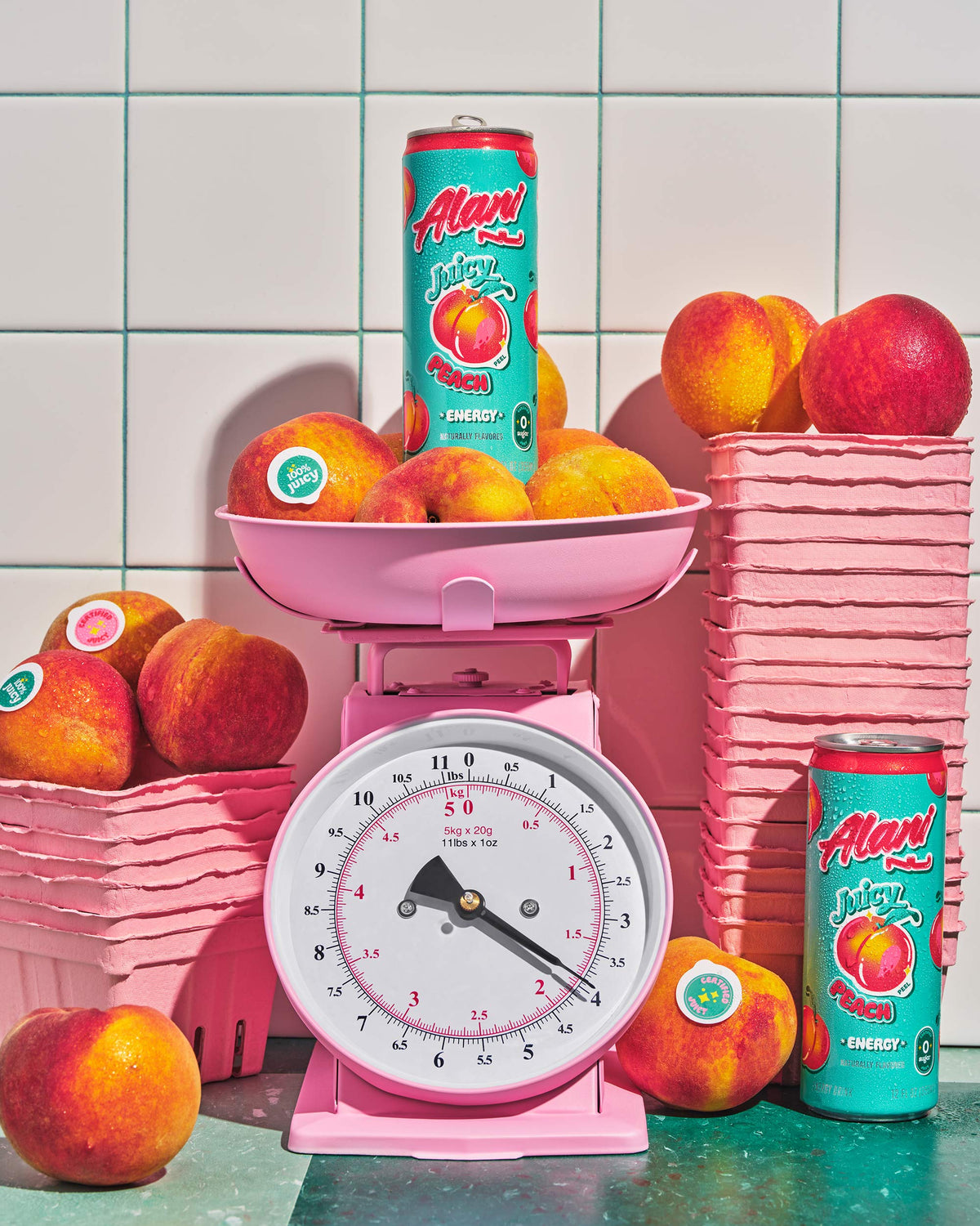 A pink food scale weighing a can of Energy Drink in Juicy Peach flavor next to peaches.