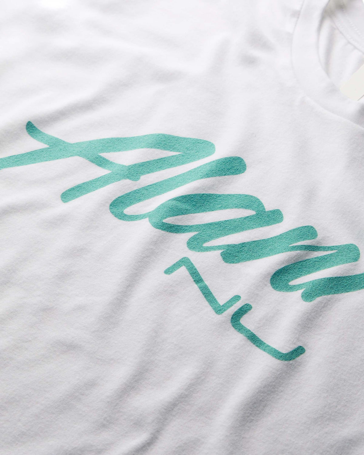 A Seafoam On White T-Shirt with green lettering on it.